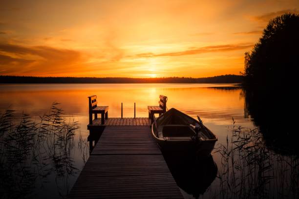 sonnenuntergang über dem fishing pier am see in finnland - season lake cloudscape horizon stock-fotos und bilder