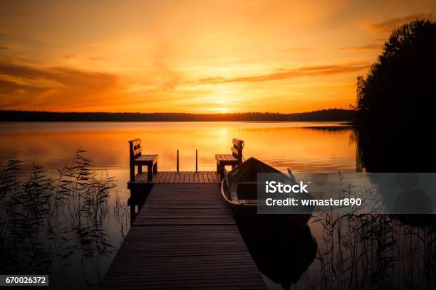 Puesta De Sol Sobre El Muelle De Pesca En El Lago En Finlandia Foto de stock y más banco de imágenes de Lago