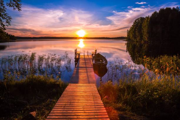 sonnenuntergang über dem fishing pier am see in finnland - season lake cloudscape horizon stock-fotos und bilder