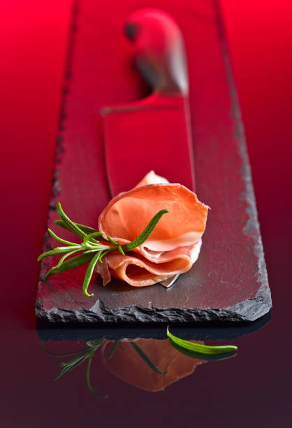 istock Prosciutto with  rosemary  on a big meat knife. 670026506