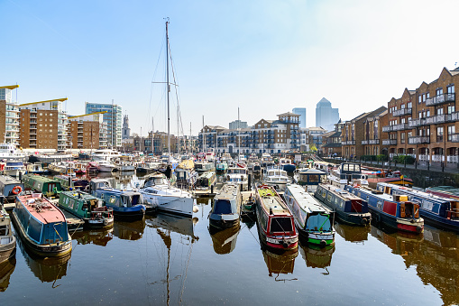 London, UK - April 08, 2017 - Boats and yachts moored at Limehouse Basin Marina with Canary Wharf in the background