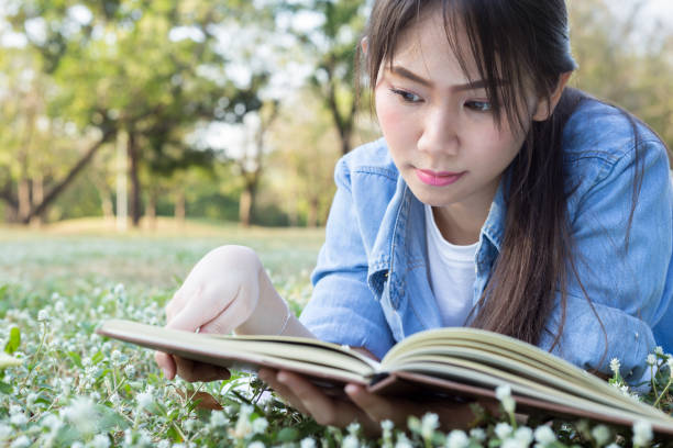 istock asian girl lying and reading books 670037452