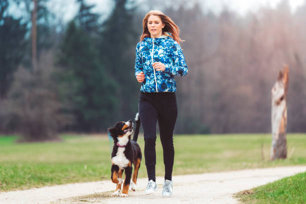 istock Young woman jogging with dog 670041112