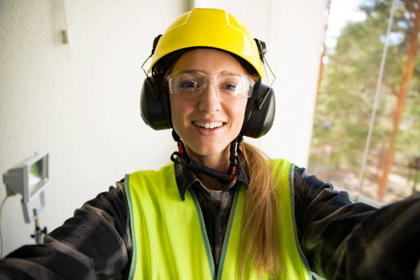 Portrait of a Young Female construction worker in hard hat Portrait of a Young Female construction worker in hard hat drilling concrete wall with a drill and smiling at the camera. Building and renovation. feminism concept. Selfie emancipation proclamation stock pictures, royalty-free photos & images