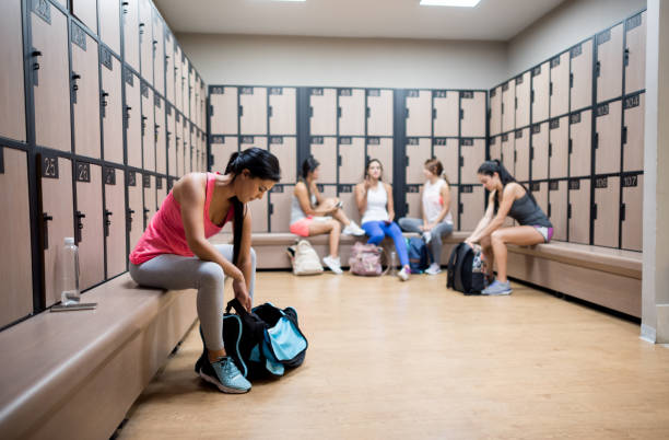 Women a the gym changing in the dressing room Women a the gym changing in the dressing room and putting their things in the lockers - healthy lifestyle concepts locker room stock pictures, royalty-free photos & images
