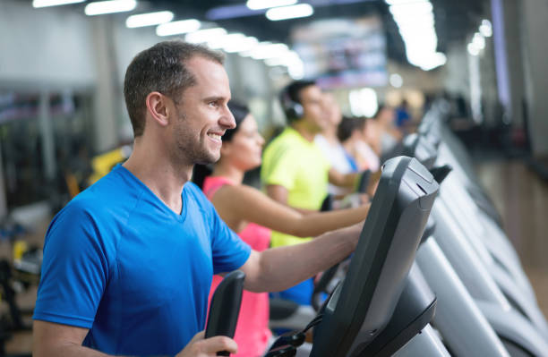 istock Happy man exercising at the gym on a cross trainer 670044966