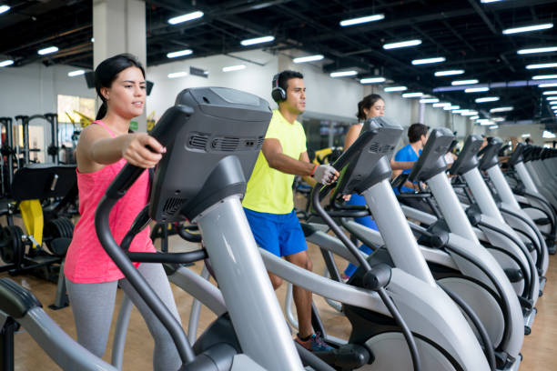 People at the gym exercising on crosstrainers