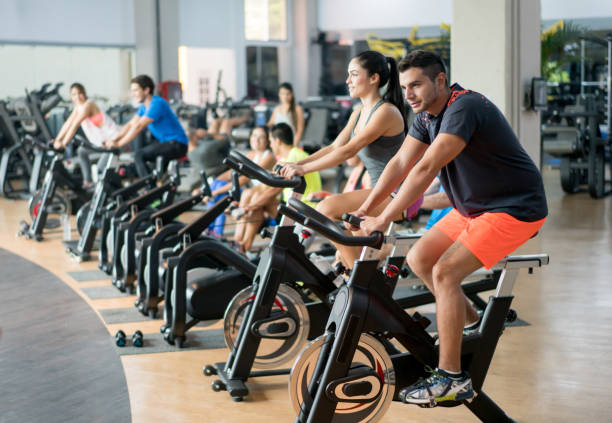 osoby ćwiczące na siłowni na rowerze - spinning gym cycle cycling zdjęcia i obrazy z banku zdjęć