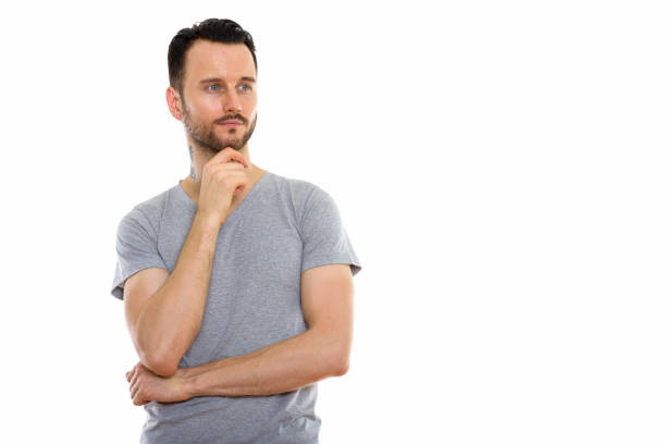 Studio shot of young man thinking while looking at distance horizontal shot
