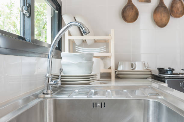 Close Up Bright Tall Faucet and Stainless Steel Sink on Luxury Marble Floor Background