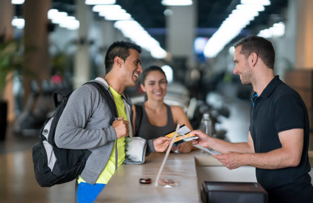 people at the gym talking to the receptionist - service member imagens e fotografias de stock