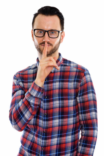 istock Studio shot of young man with finger on lips 670056300
