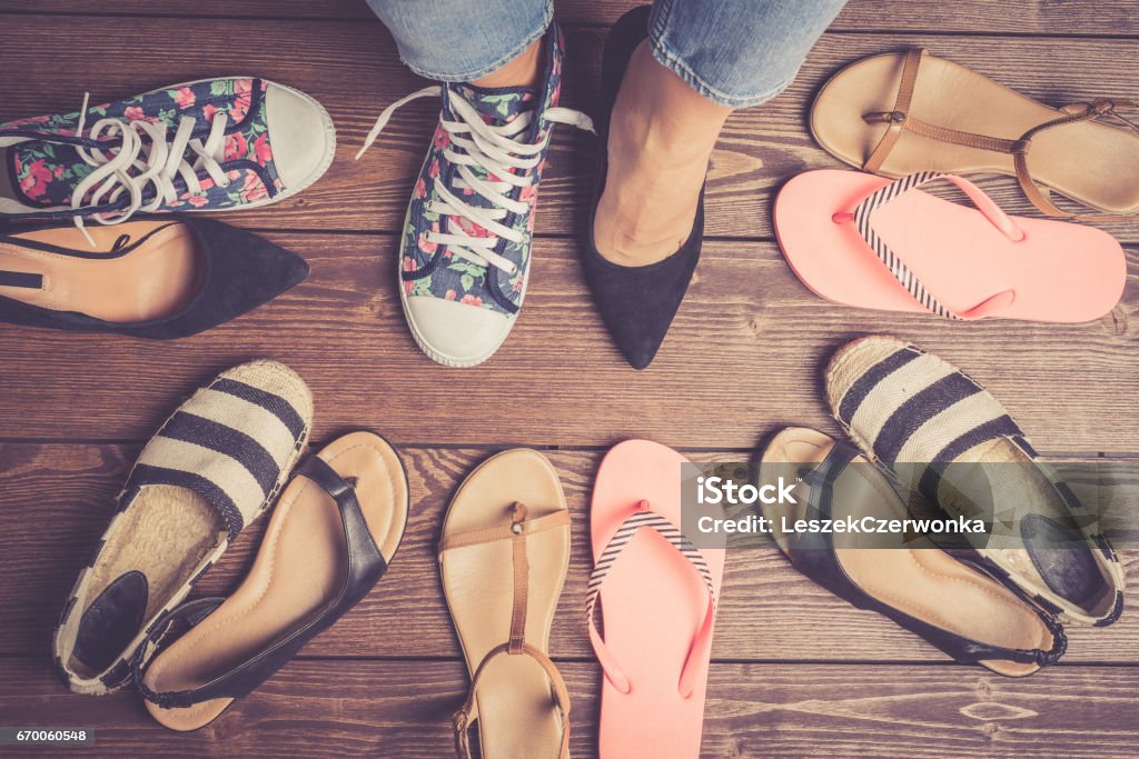 Collection of female shoes on wooden floor. Collection of female shoes on wooden floor. Fashion background Directly Above Stock Photo