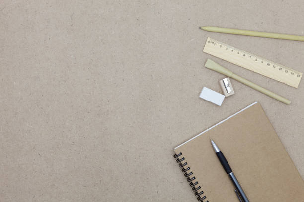 istock Notebook with pen and pencil eraser on brown paper background. 670061244