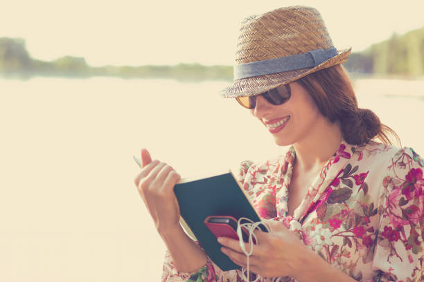 istock young woman sitting outdoors and reading a book 670061290