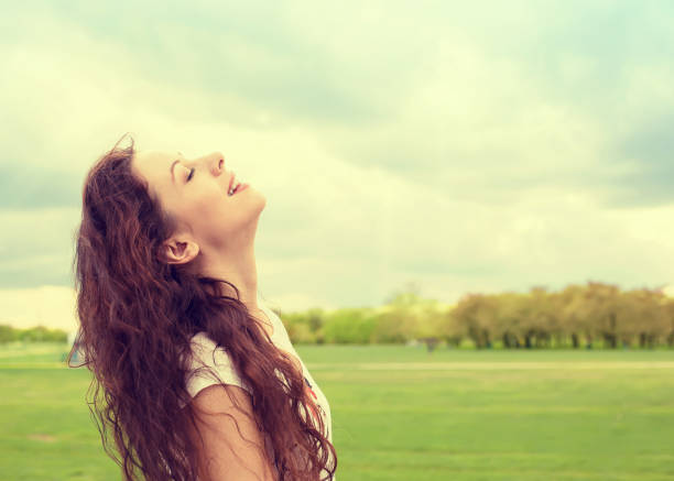 istock Side profile woman smiling looking up to blue sky celebrating enjoying freedom 670062016