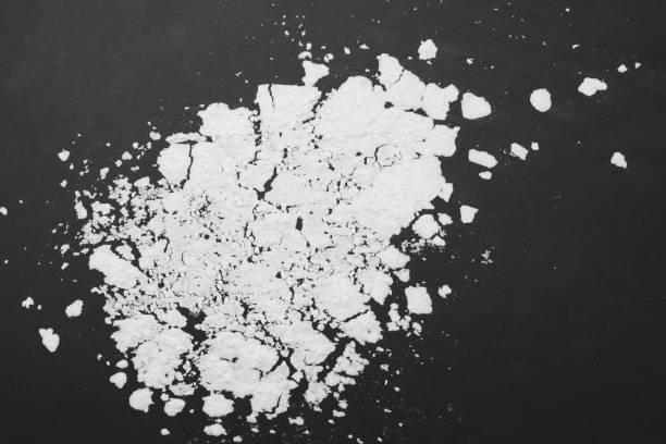 istock sprinkle wheat flour with copy space for text on dark black  background, top view for cooking dough or pastry background. 670069154