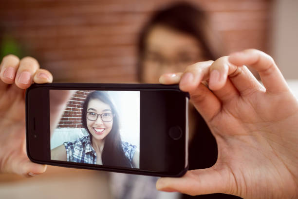 istock Asian woman on the couch taking selfie 670069232