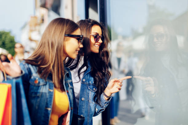 Two young women in shopping looking at shop window in the city Two young women in shopping looking at shop window in the city window shopping stock pictures, royalty-free photos & images