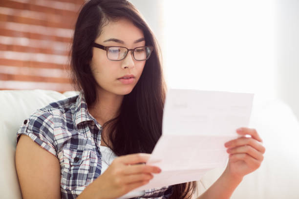 istock Asian woman on the couch reading letter 670072242
