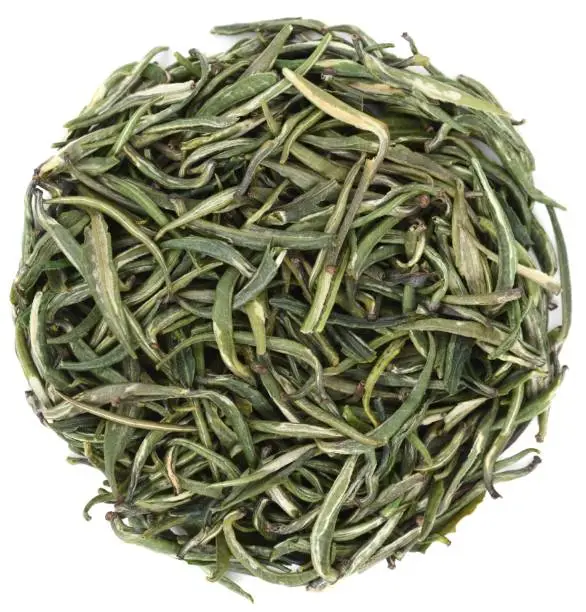 Organic green tea Zhu Ye Qing from Simao, Yunnan in round shape isolated overhead view