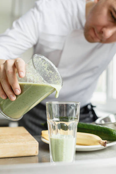 istock Male cooking fresh vegetable smoothie 670076318