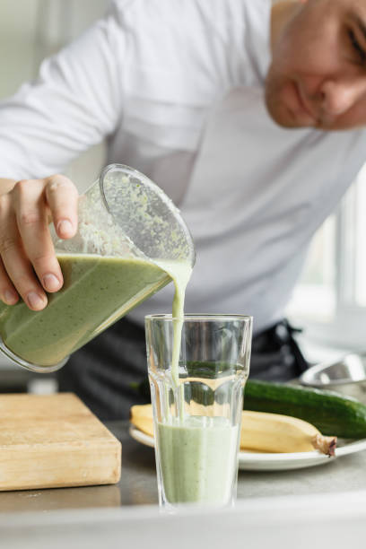 istock Male cooking fresh vegetable smoothie 670076360