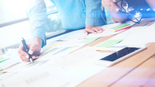 istock Closeup view of teamwork concept.Young business team working with new startup project.Smartphone on wooden table,documents and marketing reports.Blurred background,visual effect,flare.Horizontal 670076398
