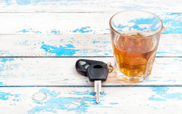 A glass of whiskey and car keys on on the old blue table. A glass of whiskey and car keys on on the old blue table. car keys table stock pictures, royalty-free photos & images
