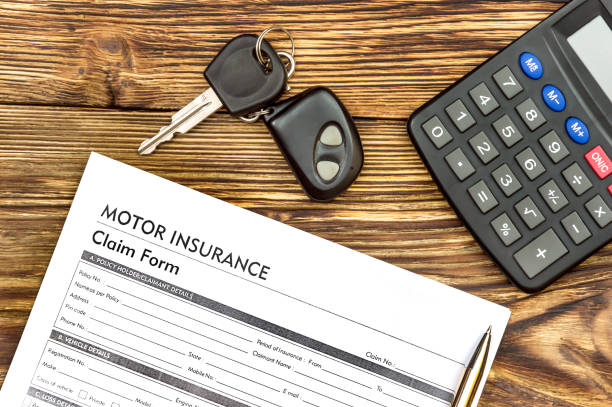 istock Motor insurance claim form with car keys and calculator on the table. 670079596