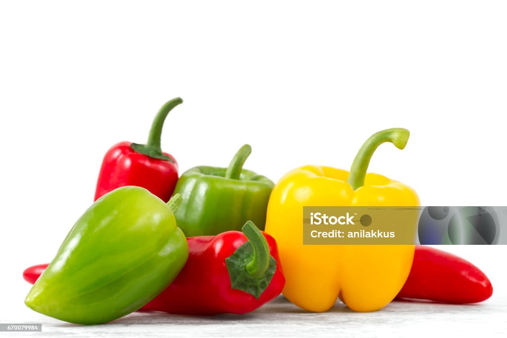Bell Peppers on Kitchen Table Bell and chili peppers on white background. Pepper - Vegetable Stock Photo