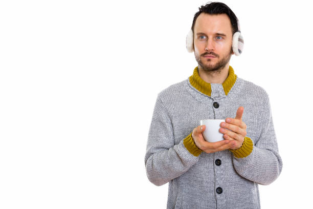 istock Studio shot of young man holding coffee cup and thinking while wearing winter earmuffs 670083652