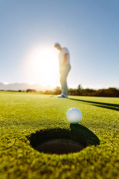 istock Professional golfer putting golf ball 670084978