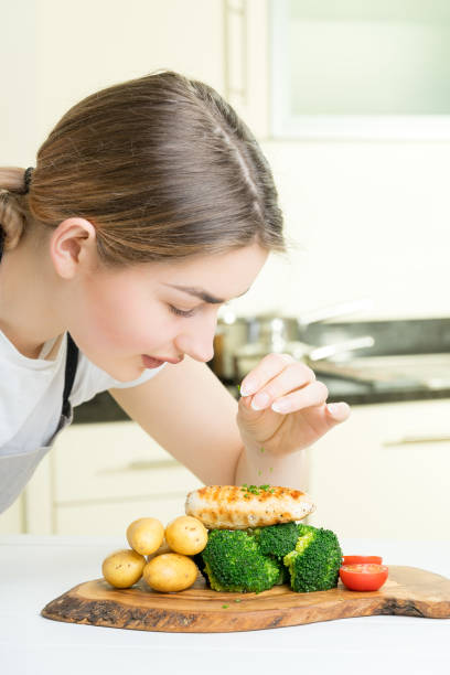 istock female chef garnish chicken vegetable dish kitchen 670092290