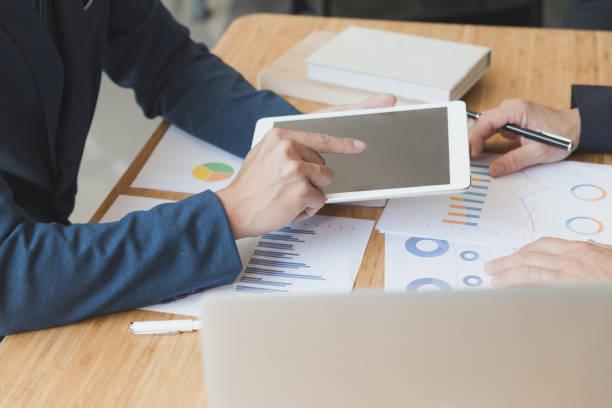 istock two young businessmen using touchpad and analysis business chart document at meeting 670102076