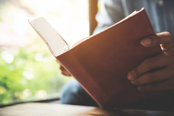 istock Focus on book. Concentrated Man holding notebook on green natural background with copy space. 670117740