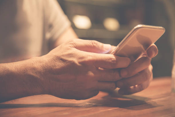 istock Close up on hands. Relaxed Asian Senior man using cell phone. 670117768