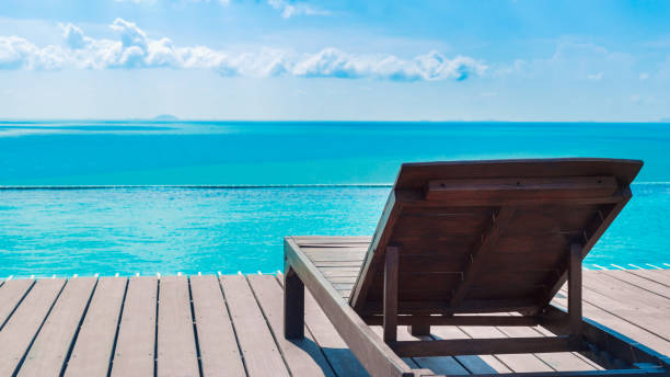 istock Beach chair on swimming pool side and blue sea 670120302