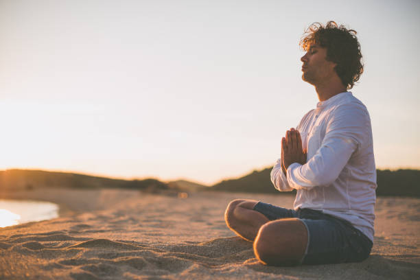 istock Zen-like position on beach in sunset 670123162
