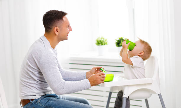 istock father feeds baby from spoon 670126138
