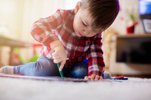 istock Beautiful little boy enjoying drawing at the floor 670133498