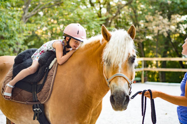 istock Girl Riding Horse In Paddock With Trainer Assisting 670133548