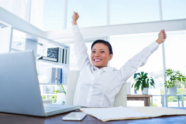 istock Businesswoman cheering behind laptop computer 670134350