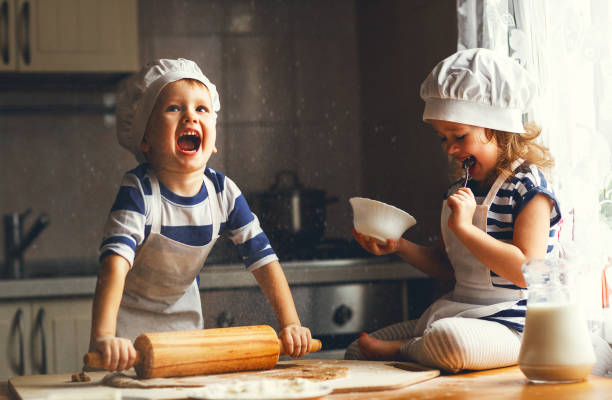 feliz familia niños divertidos hornear galletas en la cocina - christmas child cookie table fotografías e imágenes de stock
