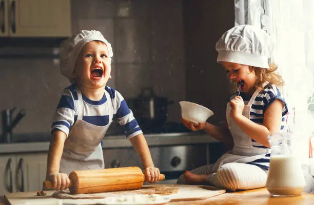 Photo of happy family funny kids bake cookies in kitchen
