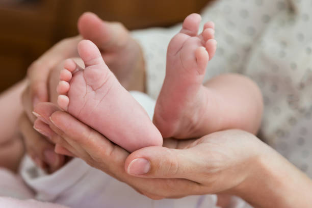 istock Parent hands gently holding baby feet from below 670136998