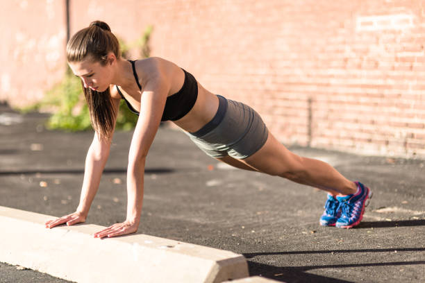 istock woman doing pushup on the street 670137366