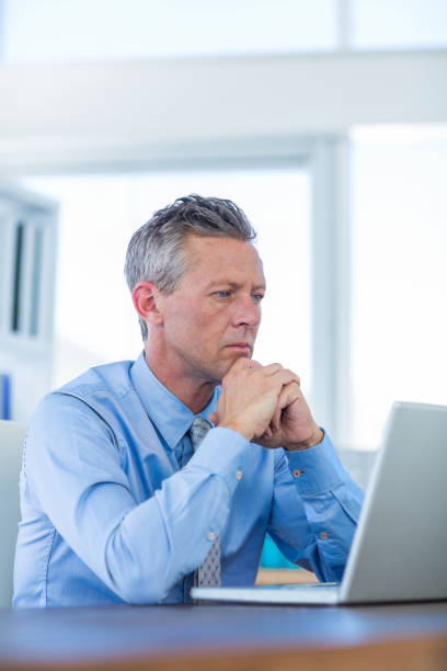 istock Concentrated businessman looking at laptop computer 670137554