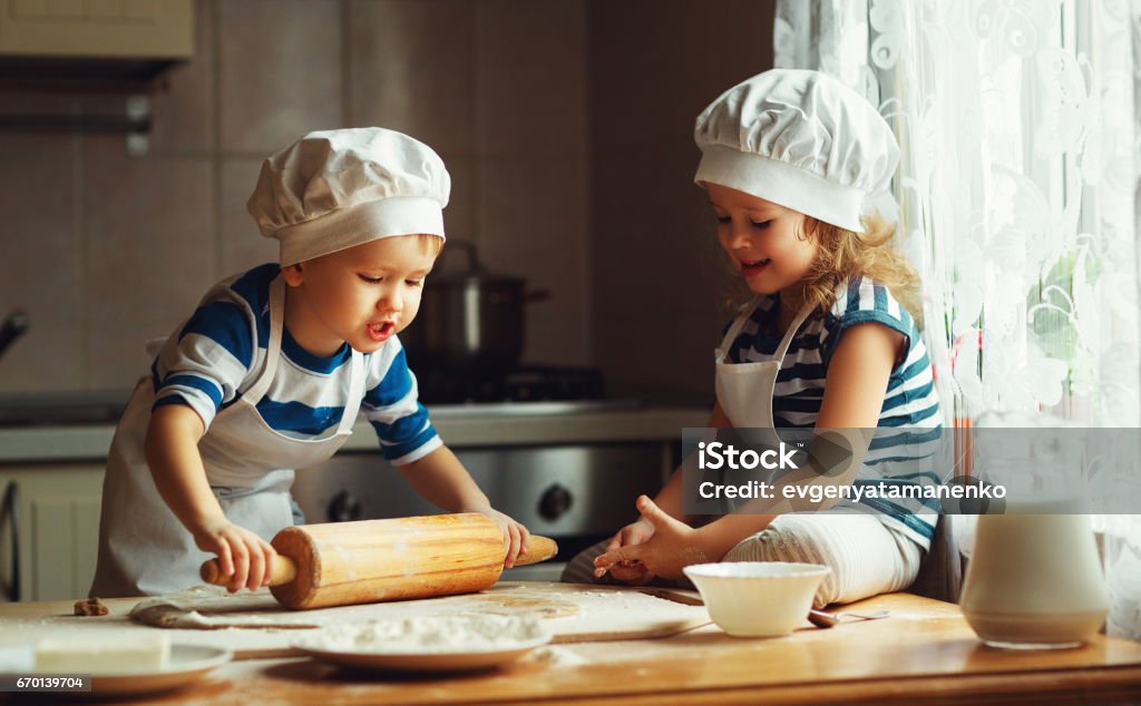 happy family funny kids bake cookies in kitchen happy family  funny kids are preparing the dough, bake cookies in the kitchen Christmas Stock Photo