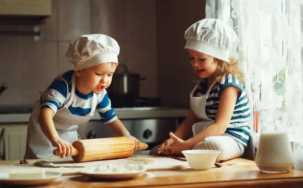 Photo of happy family funny kids bake cookies in kitchen